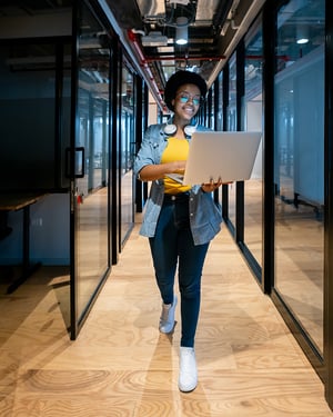 Happy-IT-technician-working-at-the-office-using-her-laptop-800x1000